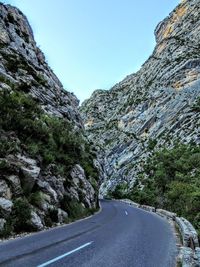 Road amidst mountains against clear sky