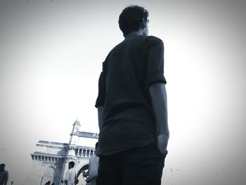 Rear view of man standing in temple against clear sky