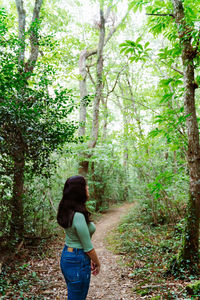 Full length of woman standing on footpath in forest