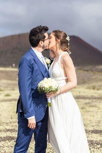 Portrait of bride and bridegroom holding bouquet