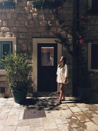 Full length portrait of woman standing on tiled floor