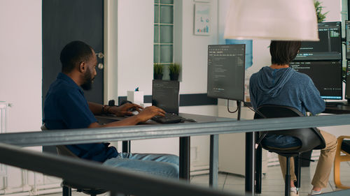 Side view of man using mobile phone in office