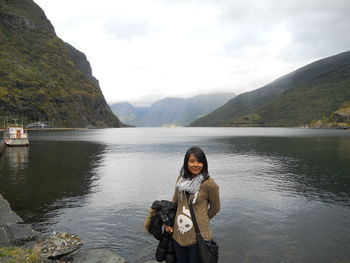 Portrait of woman standing against lake