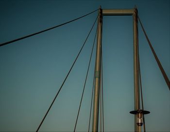 Low angle view of suspension bridge against clear sky