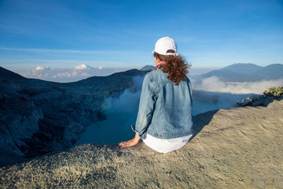 Woman on mountain against sky