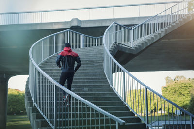 Rear view of man running on staircase