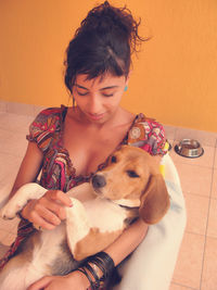 High angle view of woman holding dog while sitting on chair