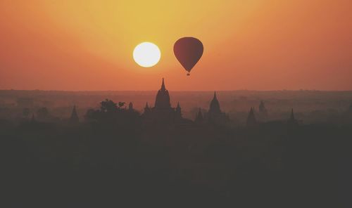 Silhouette of hot air balloons against sky during sunset