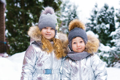 Two little cheerful children on snowy frosty day. brother and sister play