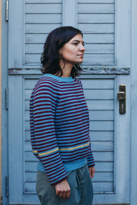 Young woman standing against wall