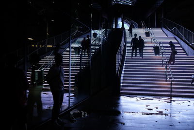 People enjoying the animated lighted staircase in the city at night