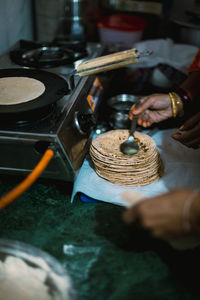 Cropped hand of woman preparing food in kitchen