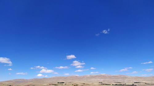 Scenic view of desert against blue sky