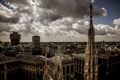 View of cityscape against cloudy sky
