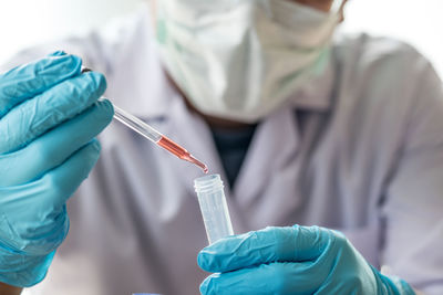 Midsection of scientist testing chemical in laboratory