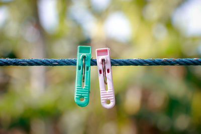 Close-up of clothespins hanging on rope