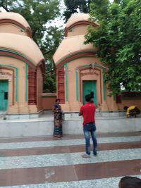 Rear view of woman walking by building