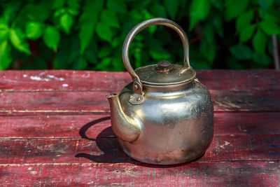 Close-up of old-fashioned tea pot on wooden table