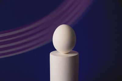 White easter egg on podium in neon and purple light