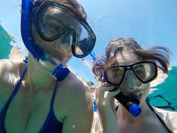 Close-up of mother and daughter snorkeling undersea