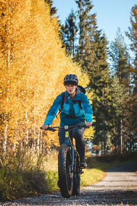 Rear view of man riding bicycle on field