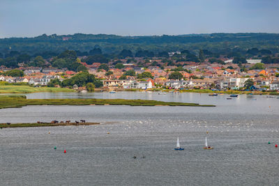 Aerial view of town by sea against sky