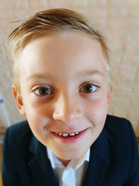 Close-up portrait of smiling boy standing at home