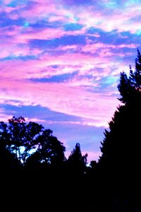 Silhouette of trees against cloudy sky