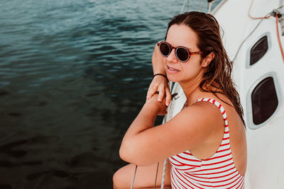 Woman wearing sunglasses while sitting in boat on sea