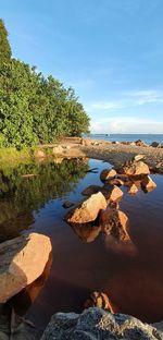 Rocks by sea against sky