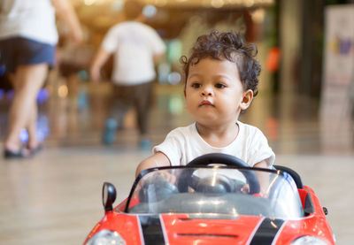 Close-up of cute boy riding toy car