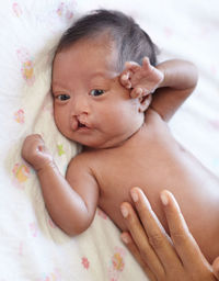 Cute baby boy sleeping on bed at home