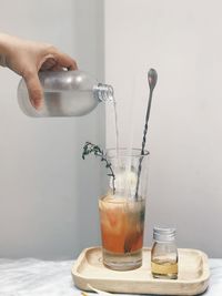 Close-up of hand pouring coffee in cup on table