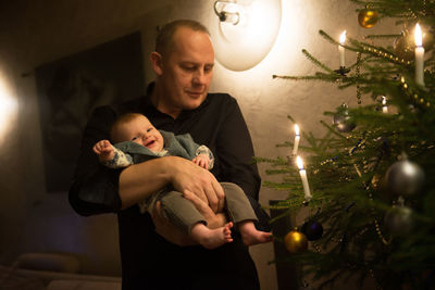 Grandfather holding cute granddaughter during christmas