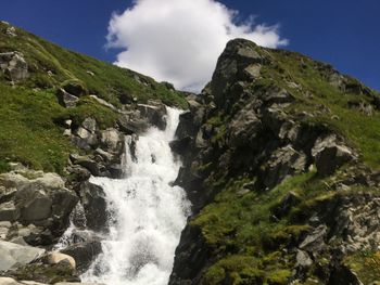 Scenic view of waterfall against sky