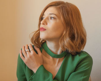 Portrait of young woman against wall