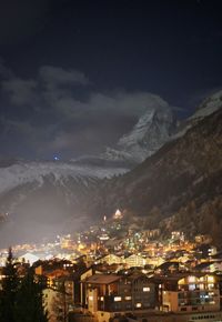 Aerial view of illuminated town against sky at night