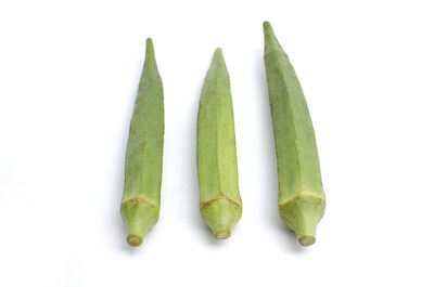 Close-up of green chili over white background