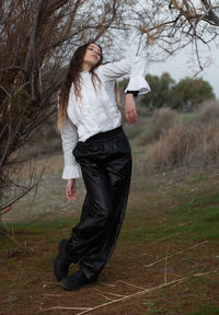 Rear view of young woman standing on field