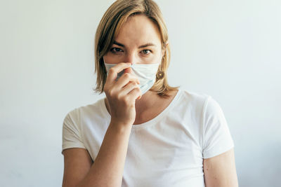 Portrait of woman wearing mask against white background