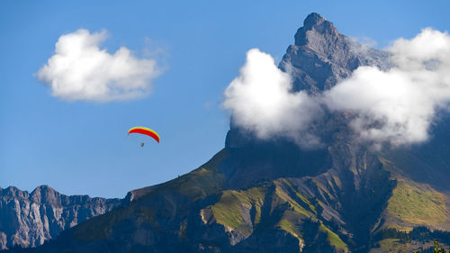 Low angle view of person paragliding against sky