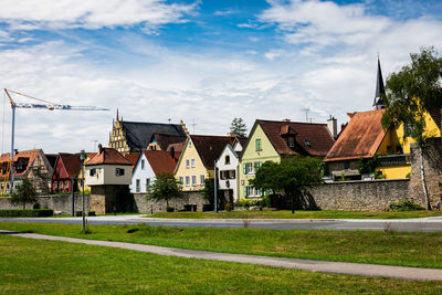 Houses in park against cloudy sky