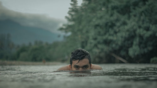 Rear view of man swimming in lake
