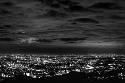 Aerial view of cityscape against cloudy sky