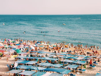 High angle view of people on beach against clear sky