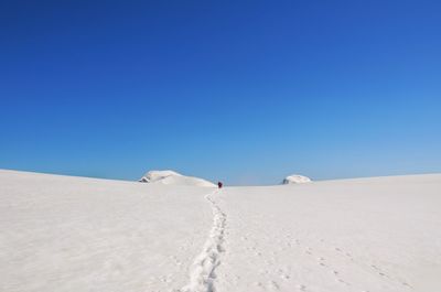 Scenic view of snow covered land against clear blue sky