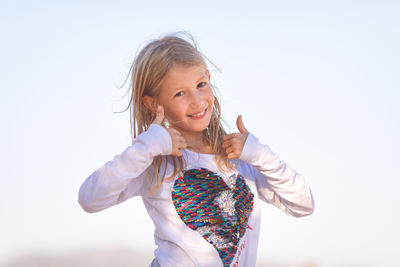 Portrait of smiling girl showing thumbs up signs