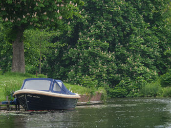 Boat moored in lake against trees in forest