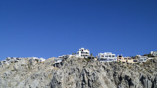 Low angle view of buildings against clear blue sky