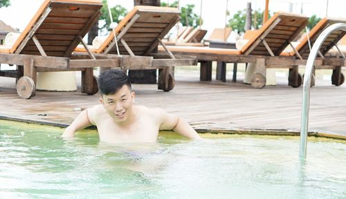 Portrait of shirtless man swimming in pool